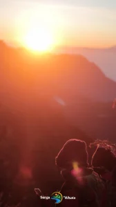 Panorama sunrise spektakuler di Gunung Bromo dengan siluet Gunung Batok dan Semeru di kejauhan, langit oranye keemasan, serta lautan pasir yang memukau